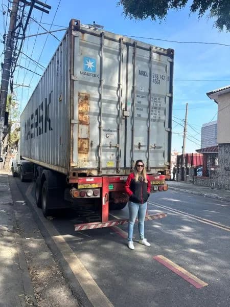 Pamela ao lado de um contêiner de importação
